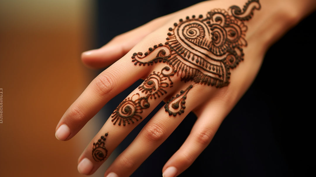 Main élégante présentant un design de henné complexe avec des motifs traditionnels spirales et paisley, sur un fond flou aux tons chauds.